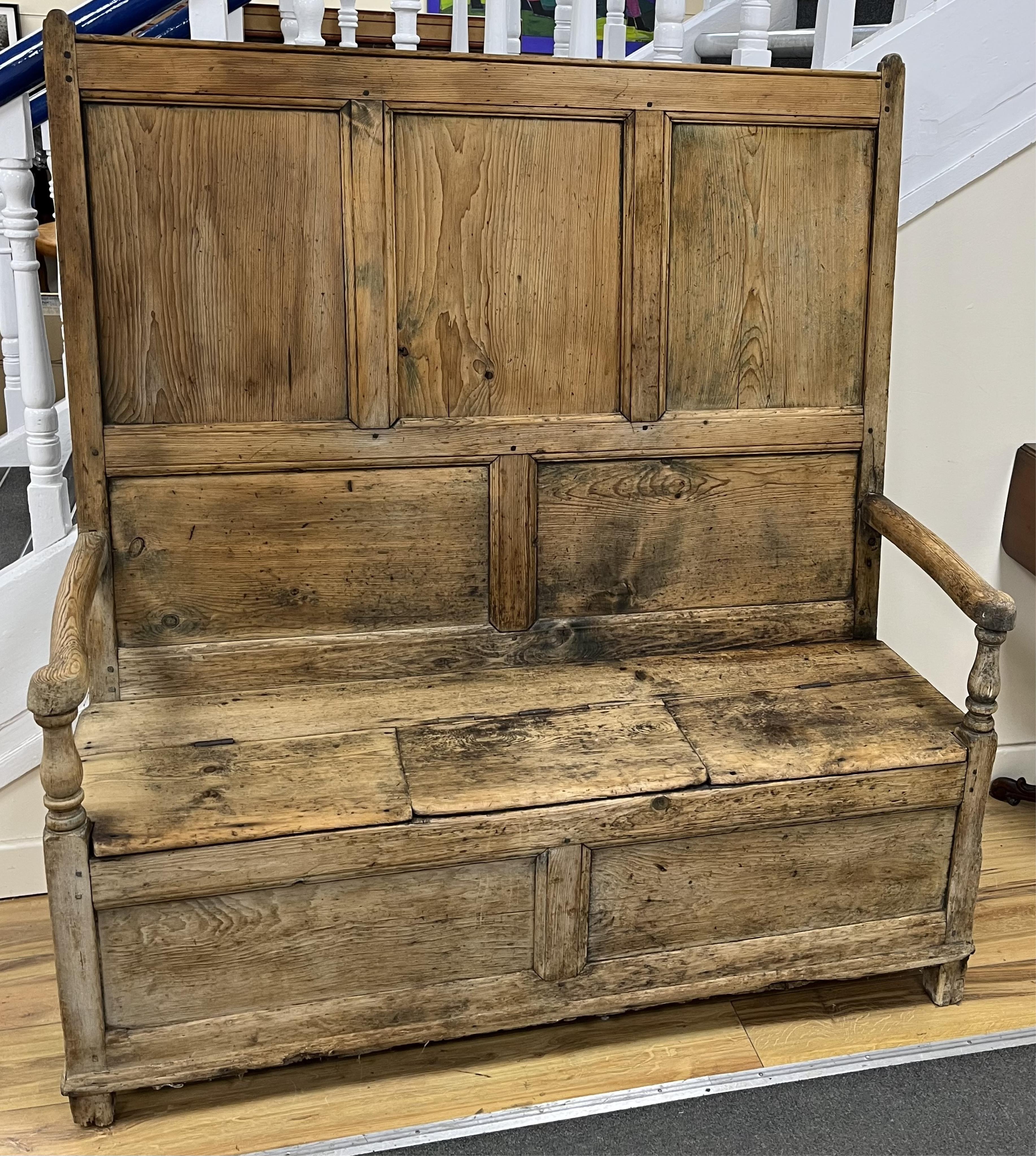 An 18th century panelled pine settle, width 127cm, depth 46cm, height 140cm. Condition - poor to fair